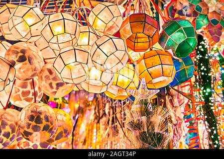 Illuminata luminosamente colorata lanterne tradizionali di sottile conchiglie di mare appeso al di fuori di un negozio a Divisoria Market a Manila nelle Filippine. Foto Stock