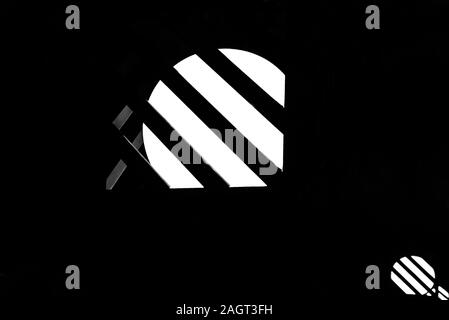 Round lampioni dietro una striscia metallica gabbia è brilla contro la notte nera dello sfondo. La foto viene ridotta al solo in bianco e nero. Foto Stock