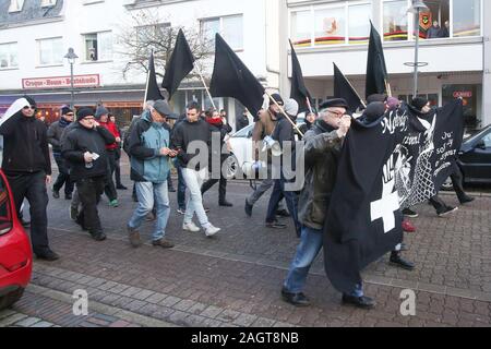 Buxtehude, Germania. Xxi Dec, 2019. I partecipanti di una piccola dimostrazione a piedi con bandiere nere attraverso il centro della città di Buxtehude. I manifestanti hanno voluto passare alla casa privata di un magistrato che ha condannato i criminali violenti dopo i tumulti in corrispondenza del vertice G20 di Amburgo nel 2017. La città di Buxtehude ne ha fatto una condizione che la marcia di protesta deve fermarsi a 800 metri dalla casa. Credito: Bodo segna/dpa/Alamy Live News Foto Stock