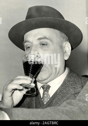 Politico italiano il ministro Umberto Tupini avente un bicchiere di vino rosso, Roma, Italia degli anni sessanta Foto Stock