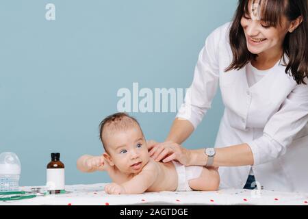 Giovane donna medico esamina un bimbo boy e sorrisi Foto Stock