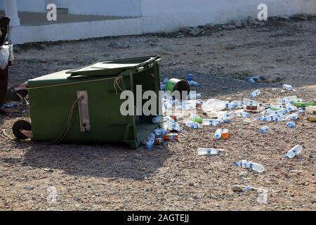 Leere Wasserflaschen aus Plastik vor einem umgestürzten Müllcontainer, Dipkarpaz, Türkische Republik Nordzypern Foto Stock