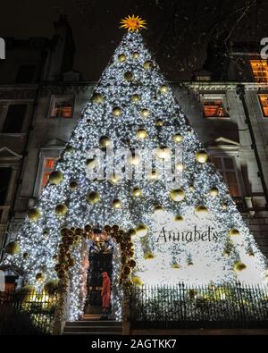 Central London, Londra, 21 dic 2019. Come di consueto, Annabel's night club in Berkeley Square è andato il miglio supplementare e mettere su un gigantesco White Christmas tree con display baubles al di fuori della loro entrata. Negozi, alberghi, ristoranti e residenze hanno tutte addobbate le sale decorate e i loro ingressi nella festosa splendore intorno a Mayfair e Oxford Street e Regent Street a Londra negli ultimi giorni prima di Natale. Foto Stock