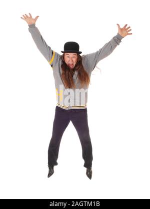Un uomo indigeno in grigio di una giacca e pantaloni neri saltando per la felicità nell'aria, isolato per sfondo bianco Foto Stock