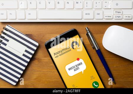 Concetto di denuncia: smartphone su un tavolo di legno con una tastiera di computer, un ordine del giorno una penna e un mouse, mostrano un fischio di avviso del ventilatore su un anonimo Foto Stock