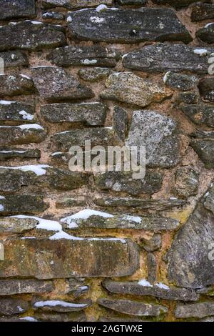 Muro di pietra con texture di neve nel Parco Nazionale Foto Stock