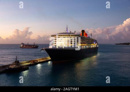 Bridgetown, Barbados - 2 Dicembre 2019: Vista di aBig lussuose Navi da Crociera ancorata in un porto durante una torbida e colorato tramonto. Foto Stock