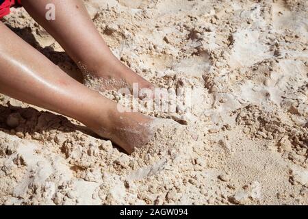 Close up Foto di mezza età della donna all'interno dei piedi di sabbia bianca sulla spiaggia durante una giornata di sole. Prese su Brownes Beach, San Michele, Barbados. Foto Stock