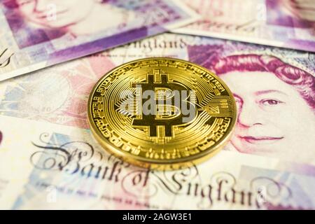 Oro cryptocurrency Bitcoin moneta su una sterlina inglese fatture. Close-up, macro shot - movimento di PAN Foto Stock
