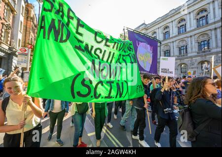 Londra - 20 settembre 2019: Cambiamento Climatico manifestanti che trasportano un banner di protesta a una ribellione di estinzione marcia di protesta su Whitehall, Londra Foto Stock