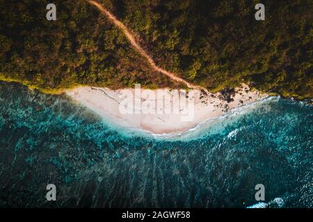 Antenna top down vista drone di scale che conducono in basso verso la coppa verde spiaggia di Uluwatu, Bali, Indonesia con il blu del mare e la sabbia bianca Foto Stock