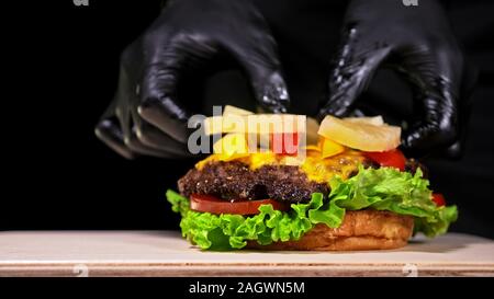 Craft burger è in cottura. Sono costituiti da: salsa rossa salsa, lattuga, cipolla rossa, sottaceti, formaggi, peperoncino pepe verde, aria bun e in marmo la carne di manzo. Foto Stock