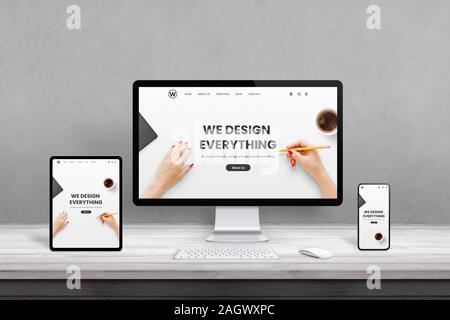 Web design studio con più dispositivi sulla scrivania in ufficio. Concetto di reattivi, piatto pagina web design. I moderni dispositivi con bordi sottili sulla scrivania in legno Foto Stock