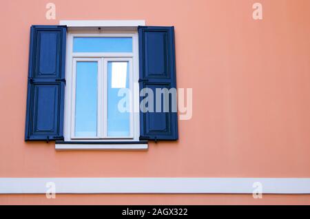 Finestra sulla parete rosa. Porte in legno apertura laterale. Foto Stock
