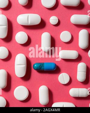Pillole su una tabella di colore rosa. Foto Stock