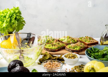 Panini con avocado guacamole su una tavola di legno sul tavolo. Cibo sano concetto in cucina. Copia spazio per il testo. Foto Stock