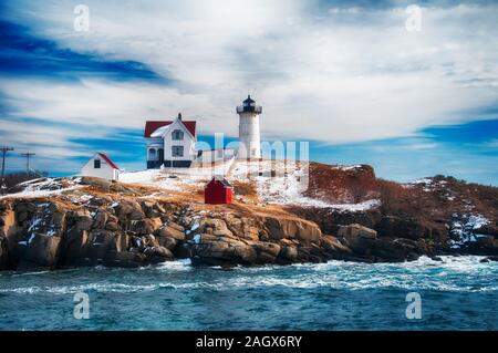 Il Cape Neddick nubble Lighthouse è un faro di Cape Neddick, York County, Maine, Stati Uniti dopo una tempesta di neve su un cielo blu giornata di sole. Foto Stock