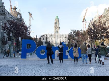 Vista posteriore di anonimi viaggiatori di ammirazione e di ripresa di Porto Azzurro iscritto installato sulla storica via della città Foto Stock