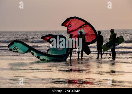 Essaouira, Marocco - Settembre 2017: kite surfers di ritorno dal mare come il sole tramonta Foto Stock