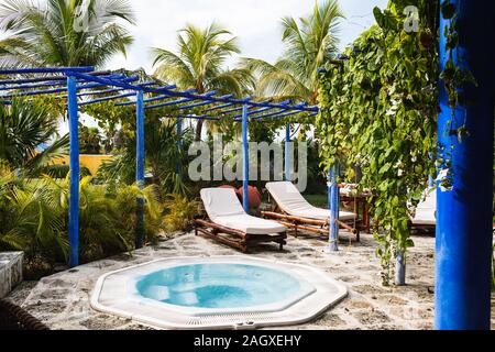 le sedie da letto di bambù, il piccolo tavolo sono sotto il tetto di legno blu in giardino Foto Stock