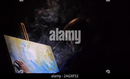 Artista copista paint seascape con nave in oceano. Fumo Vaper vape e-sigaretta. Artigiano arredatore disegnare come barca vela sul mare blu con colori acrilici. Foto Stock