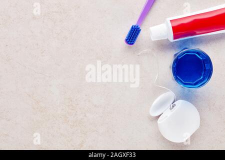 Spazzolino da denti, dentifricio, filo interdentale e collutorio sul bagno di marmo il ripiano del bancone. Cura dentale attrezzatura. Vista superiore Foto Stock