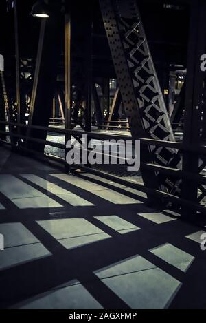 Le ombre proiettate da 'L' stazione ponte ferroviario sul marciapiede nel centro di Chicago, Illinois, Stati Uniti d'America Foto Stock