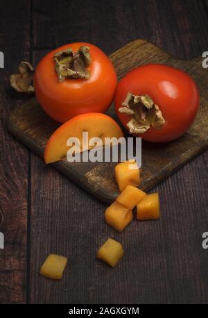 Freschi maturi cachi sul tagliere di legno Foto Stock