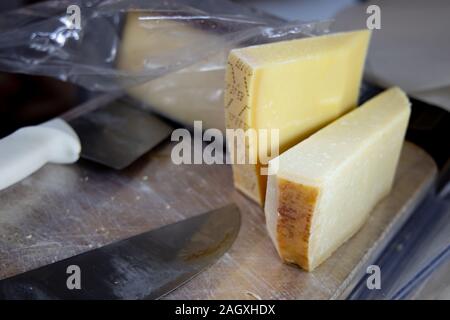 Ruote di formaggio stagionato in vendita nel mercato locale in stallo. Pienza, Toscana, Italia. Foto Stock