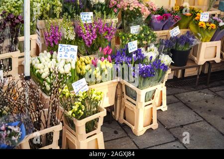 Varie specie di fiori in mostra al fiore di strada in stallo nel mercato di Londra, mazzi visualizzato all'interno di cassette in plastica Foto Stock