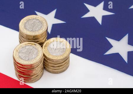 Impilati £1 monete su American Stars & Stripes flag. Metafora US-UK Trade deal post Brexit, Sterline etasso di cambio, il valore in dollari della sterlina, esportazioni britanniche di noi Foto Stock