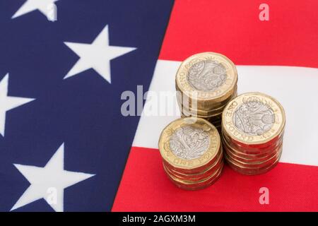 Impilati £1 monete su American Stars & Stripes flag. Metafora US-UK Trade deal post Brexit, Sterline etasso di cambio, il valore in dollari della sterlina, esportazioni britanniche di noi Foto Stock