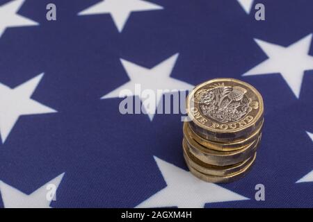 Impilati £1 monete su American Stars & Stripes flag. Metafora US-UK Trade deal post Brexit, Sterline etasso di cambio, il valore in dollari della sterlina, esportazioni britanniche di noi Foto Stock