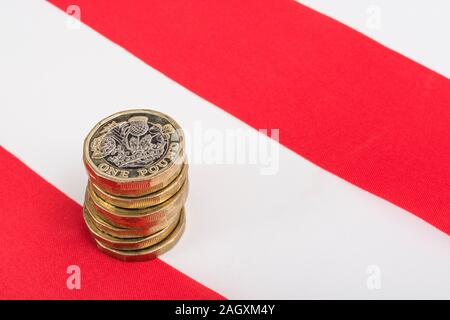 Impilati £1 monete su American Stars & Stripes flag. Metafora US-UK Trade deal post Brexit, Sterline etasso di cambio, il valore in dollari della sterlina, esportazioni britanniche di noi Foto Stock