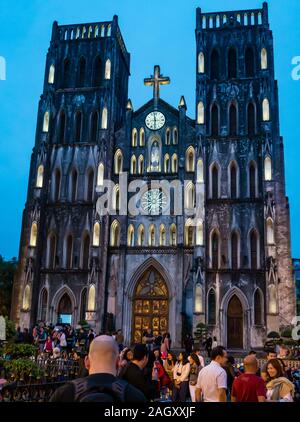 Persone a San Giuseppe Cattedrale accesa fino al crepuscolo, Church Street, Hoan Kiem District, Hanoi, Vietnam, sud-est asiatico Foto Stock