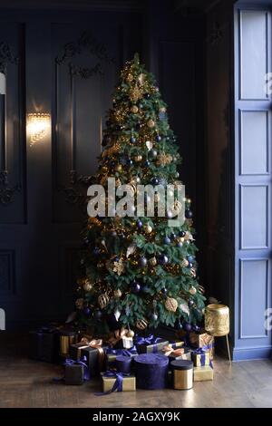 Bella e alte albero di Natale in salotto. Regali di natale vicino all'albero. Foto Stock