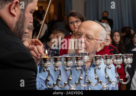 Bremen, Germania. 22 Dic, 2019. Rabbi Natanel Teitelbaum (l) accende un cero Hanukkah insieme con superstite dell' Olocausto Grigori Skoblov (90) all'Hanukkah celebrazione nella Comunità Ebraica centro a Brema in occasione del 'International superstiti notte' del popolo ebraico rivendicazioni da conferenza. La cerimonia in onore dei sopravvissuti all Olocausto avrà luogo anche a Monaco di Baviera, New York, Mosca, Parigi e Gerusalemme. Credito: Jörg Sarbach/dpa/Alamy Live News Foto Stock