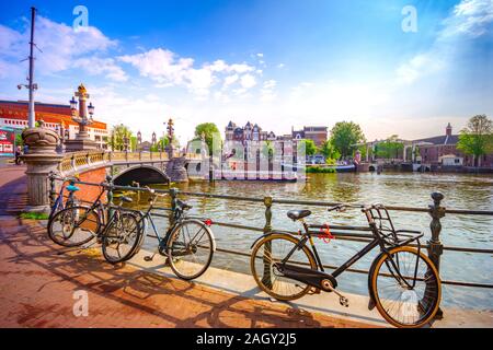 Amsterdam, con fiori e biciclette sui ponti su canali, Holland, Paesi Bassi. Foto Stock