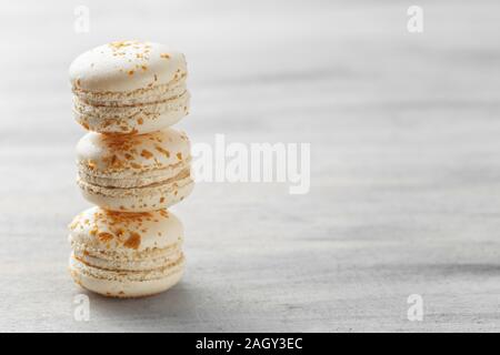 Macarons francese. Pila di pralina bianco amaretti su sfondo grigio. Spazio di copia Foto Stock