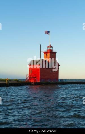 Grande faro rosso come il sole sorge su una bella mattina di autunno. Holland, Michigan, Stati Uniti d'America Foto Stock