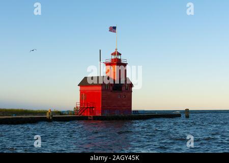 Grande faro rosso come il sole sorge su una bella mattina di autunno. Holland, Michigan, Stati Uniti d'America Foto Stock