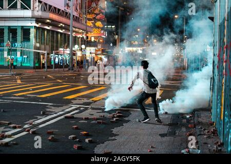 HongKong - Novembre 2019: il giovane uomo che corre dal gas lacrimogeni durante il 2019 HongKong proteste Foto Stock