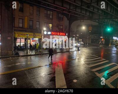 Notte piovosa sotto la metropolitana sopraelevata le vie su New Utrecht Avenue nel Quartiere Park quartiere di Brooklyn, New York. Foto Stock