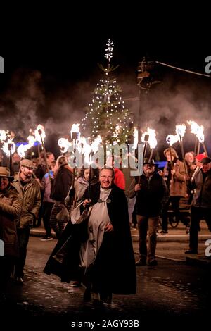 East Hoathly, UK. 22 dicembre, 2019. Gli abitanti di un villaggio di lavorazione a lume di torcia dal Kings Head pub A Christmas Carol service presso east hoathly chiesa in East Sussex, Regno Unito. La figura mostra il Reverendo Phil Hodgins portando la processione. Credito: Jim Holden/Alamy Live News Foto Stock