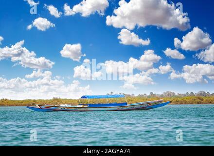 Tradizionale in legno colorato barca sul fiume in mare laguna e un bellissimo cielo in background, Africa Senegal. Foto Stock