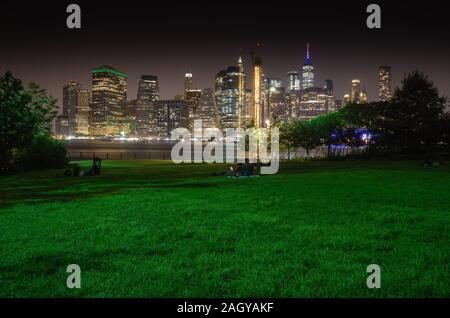 Tempo di esposizione lungo di New York City Manhattan skyline del centro di notte vista dal Ponte di Brooklyn Park Foto Stock