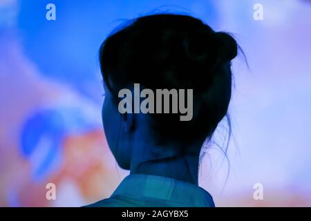 Giovane donna guardando intorno al moderno salone coinvolgente Foto Stock