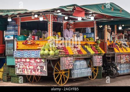 Uomo marocchino la vendita di frutta e succhi di frutta nel mercato di Marrakech Foto Stock