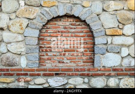 Muro di pietra con murate finestra rotonda, adeguato spazio per il testo Foto Stock