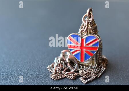 Souvenir da Gran Bretagna - collana con pendente di Big Ben figura a forma di cuore bandiera britannica grigio sulla superficie metallica con profondità di campo Foto Stock